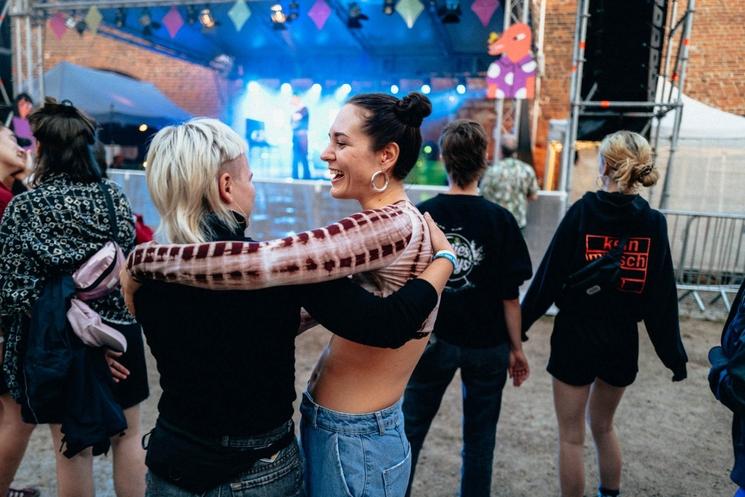 Deux femmes s'enlacent devant scène festival