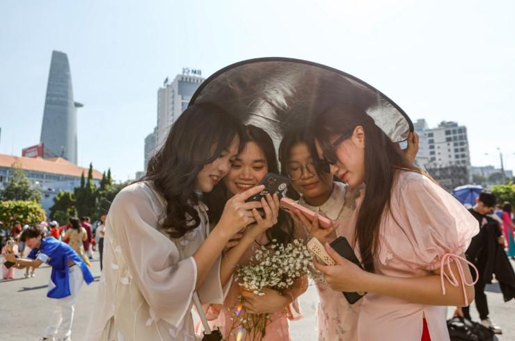 Des jeunes vietnamiens prennent des photos