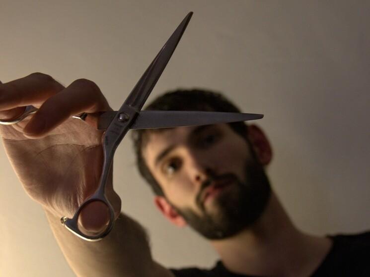 Portrait de Jim Shaper coiffeur à Berlin, tenant des ciseaux