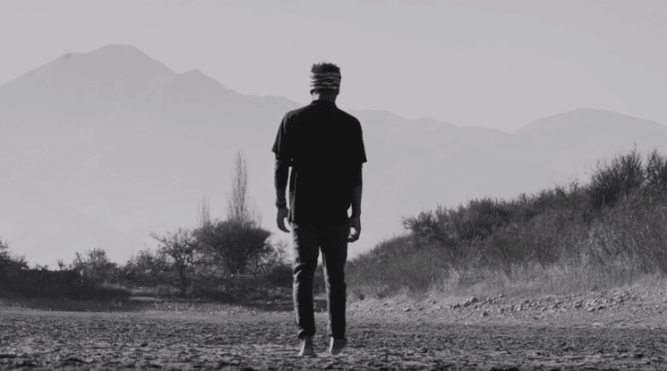 homme haïtien marchant face à la montagne