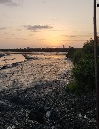 Coucher de soleil sur fond de déchets plastique à Mumbai