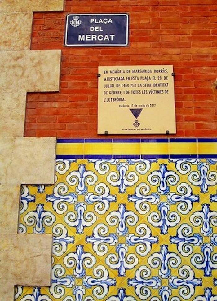 une plaque commémorative de Margarida Borras sur un mur orange avec des azulejos jaunes