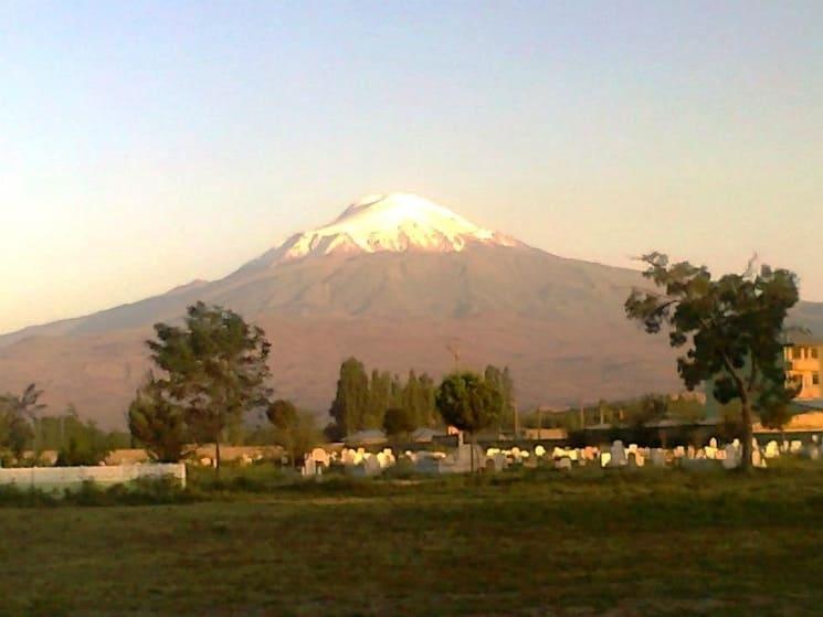 Vue panoramique du Mont Ağrı en Turquie, sommet enneigé avec un paysage verdoyant et un cimetière en premier plan, août 2012