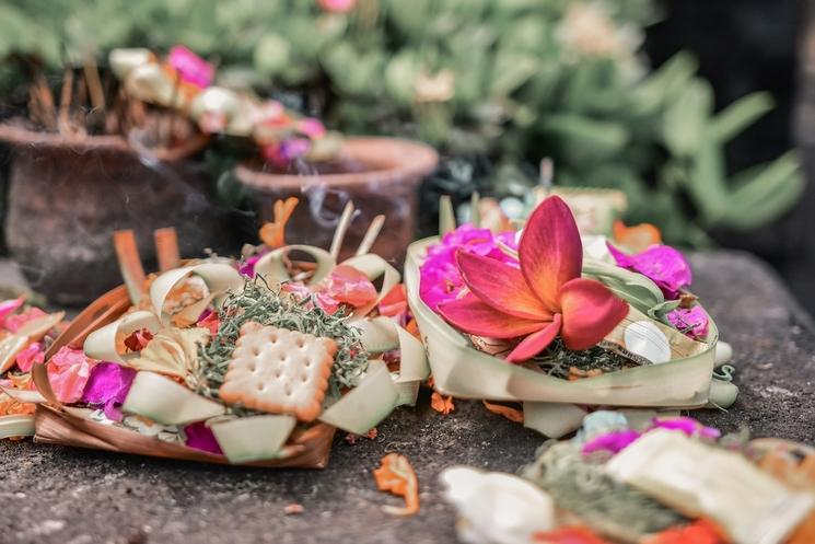 trois offrandes canang sari à bali avec fleurs, biscuit et encens