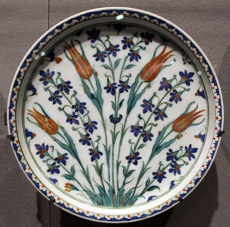 Plat en céramique d’Iznik du XVIe siècle orné de tulipes rouges sur fond blanc, art ottoman