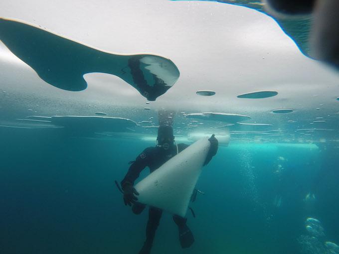 un plongeur salue sous la glace