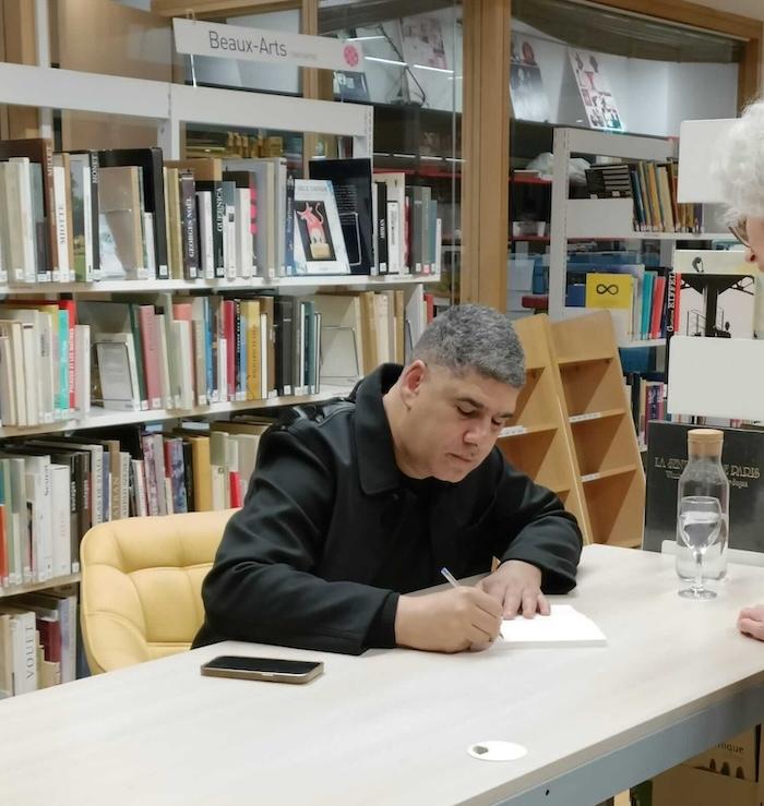 rachid benzine en train de dédicacer un livre à l'institut français de madrid