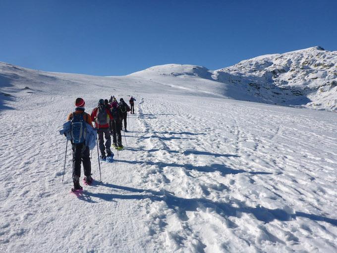 Des gens se promènent en raquettes sur les cimes de la montagne