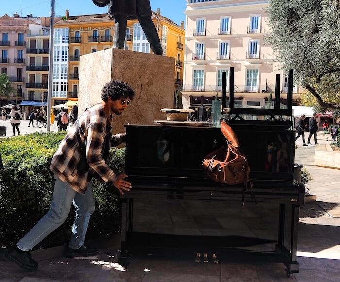 Siyels en train de pousser son piano de 128 kg sur la Plaza de la Reina