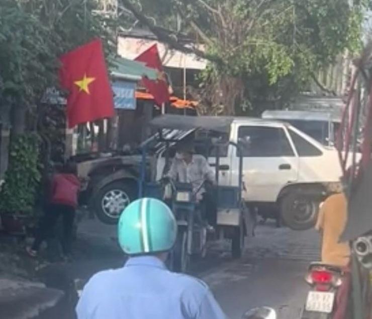 Tricycle transportant une voiture dans les rues d’HCM Ville