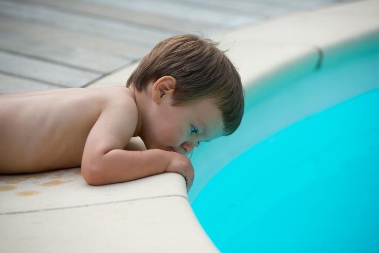 un enfant se penche au bord d'une piscine