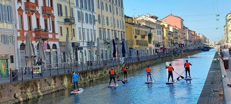 un groupe de personnes fait du paddle sur le canal de milan