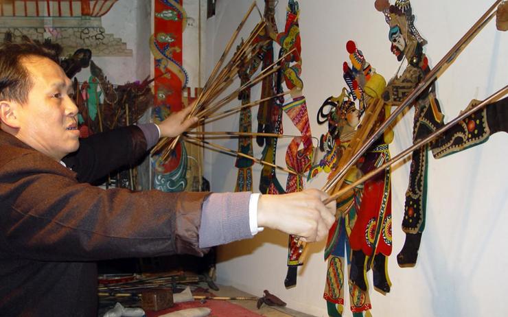 un homme fait un spectacle d'ombres chinoises