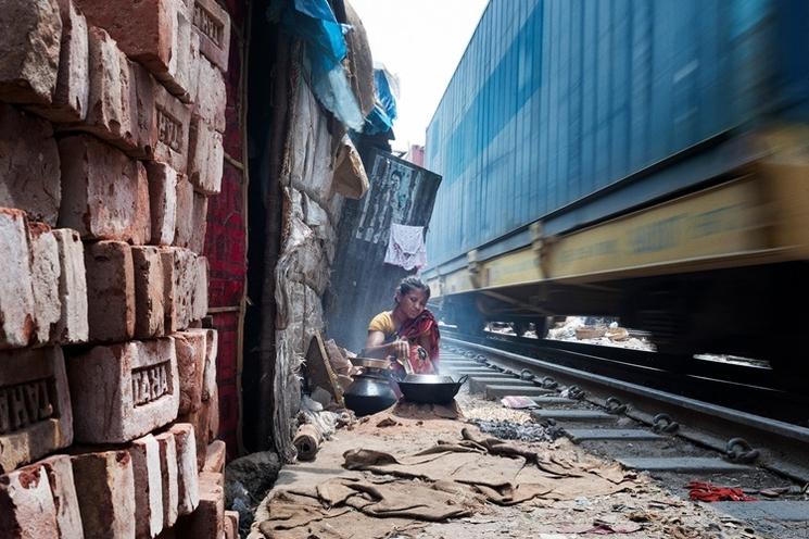 une femme cuisine par terre près d'un train