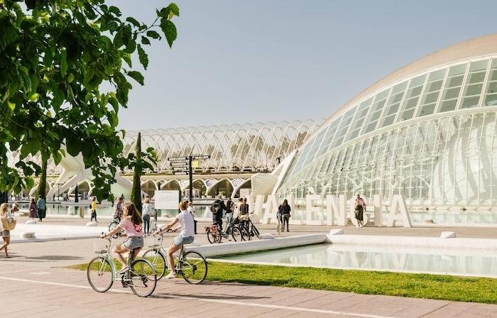 des touristes à vélo à valencia devant la cités des arts et des sciences