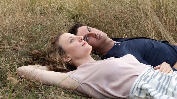 Alma et Tom, personnages principaux du film, fixant le ciel, allongés dans l'herbe