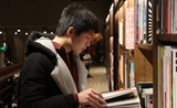 Un jeune chinois qui lit un livre dans une librairire