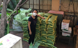 Claire devant des sacs de riz recoltés