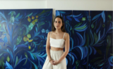 Chloe Manasseh pose devant son tableau