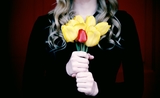 Une femme en tenue de deuil, un bouquet de fleurs à la main