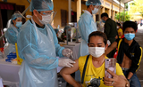 Cambodgienne se prenant en selfy durant sa vaccination