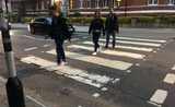 3 personnes traversent le passage clouté d'Abbey Road 