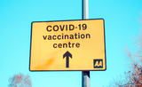 Un panneau qui indique la direction à suite pour aller au centre de vaccination contre la covid-19