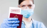 Une femme tient un passport vaccinal entre les mains