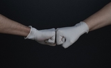 Poing à poing entre deux mains portant des gants en plastique