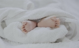 Les pieds d'un bébé dépassant d'une couette