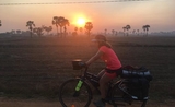 Clotilde sur son vélo au coucher du soleil au Cambodge