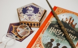 Les livres de la saga Harry Potter et une baguette trônent sur une table 
