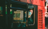 Une personne portant un masque dans un bus londonien