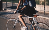 Une femme en jupe à vélo.