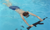 Un enfant nageant dans une piscine avec une arme à feu