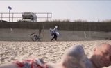 Banksy se promène sur une plage en arrière plan, juste après avoir réalisé une de ces oeuvres