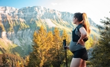 Une femme enceinte contemple les montagnes, en pleine randonnée