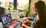une jeune fille prend des cours en ligne chez elle devant son ordinateur 