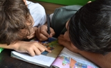Deux écoliers lisant un livre