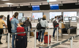 Personnes attendant leur check-in à l'aéroport BER