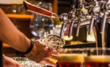 Un barman en train de servir des bières dans un pub londonien