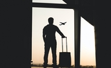 un voyageur avec sa valise, dans un aéroport