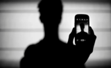 Une silhouette tenant un téléphone