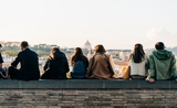 Des trentenaires assis sur un muret à Rome