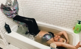 Une femme déguisée en sirène dans sa baignoire