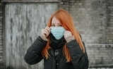 femme rousse avec un masque contre le covid en Suède