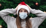 une jeune femme avec un chapeau de Noël et un masque hygiènique, en Catalogne