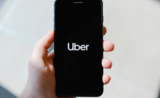 Log de Uber sur un téléphone tenu par un homme