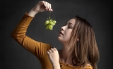 une jeune femme avec une grappe de raisins, en Espagne