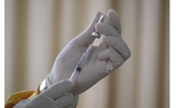 une main preparant une injection de vaccin